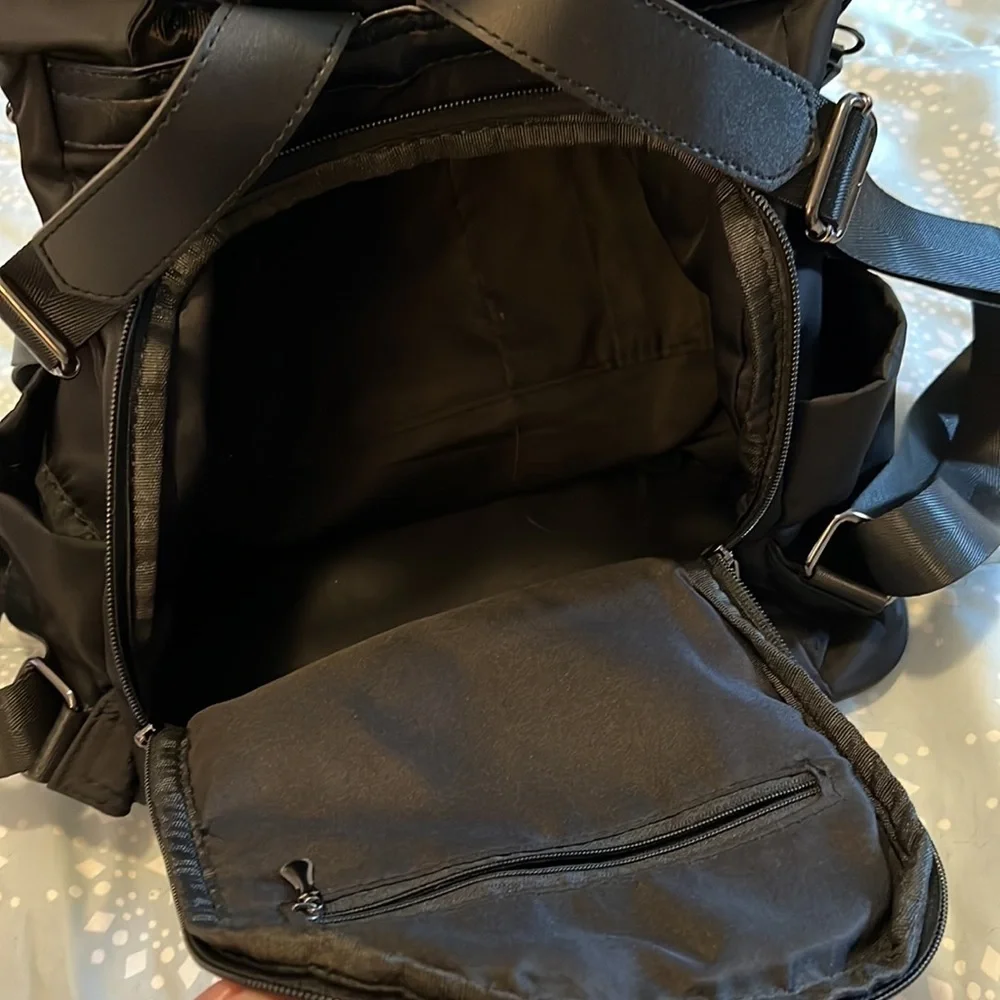 Black backpack, with strap and handle.